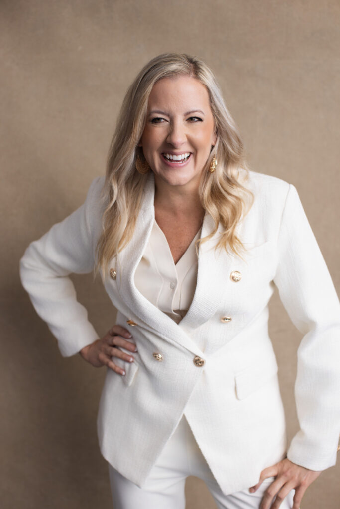 Katie Stuart laughing in white suit during professional studio portrait session