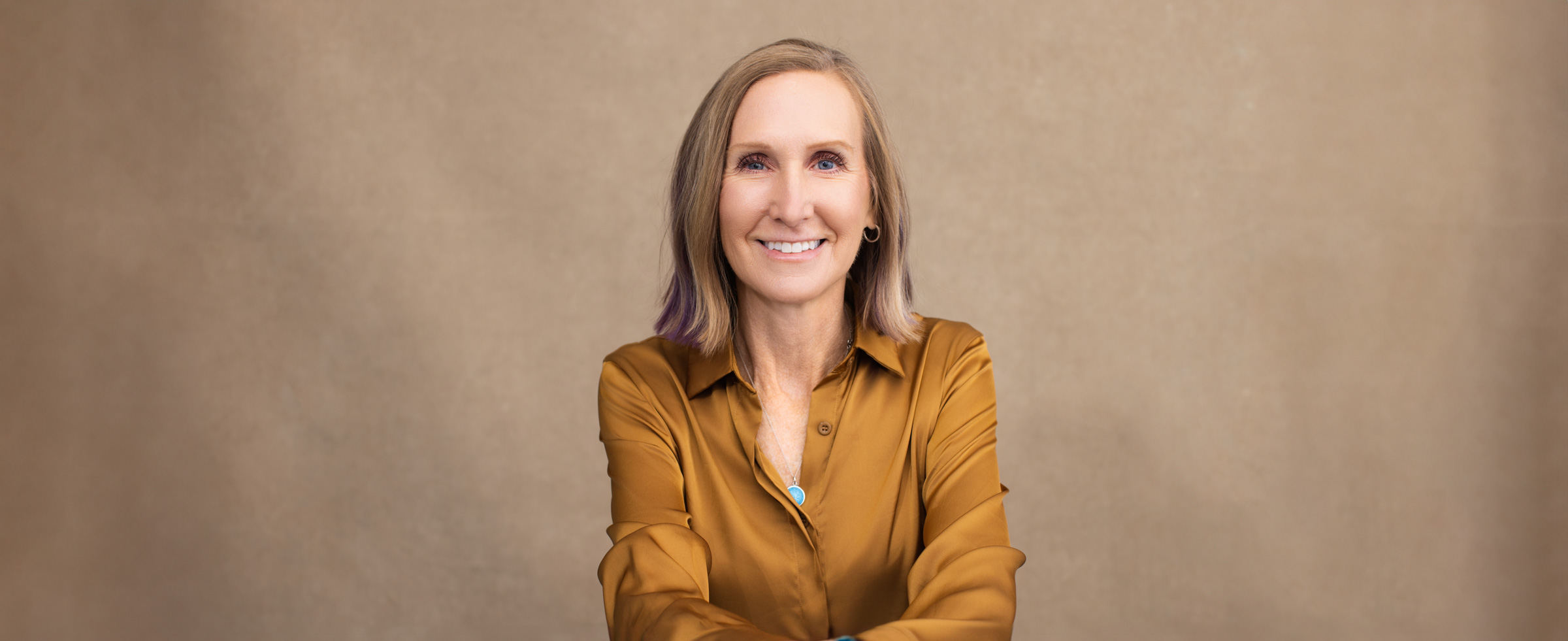 Headshot of Susan Colby wearing gold blouse in Cincinnati portrait studio
