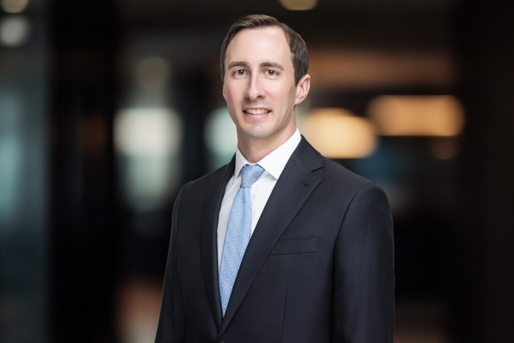 Professional headshot of wealth management partner Kyle in Cincinnati Ohio wearing a suit and tie in a modern office setting