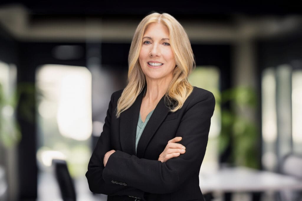 Executive portrait of Shelly Wight standing with arms crossed in a modern office setting during a Cincinnati Ohio branding session.