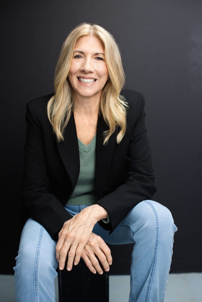 Professional headshot of executive and functional health coach Shelly Wight seated and smiling in a black blazer and jeans during a Cincinnati Ohio personal branding session